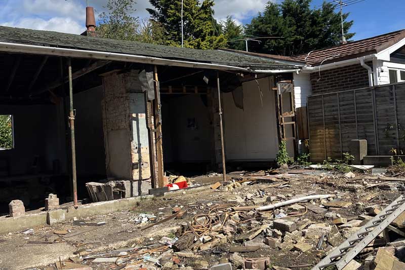 Internal structure of old bungalow exposed during demolition phase in West Sussex